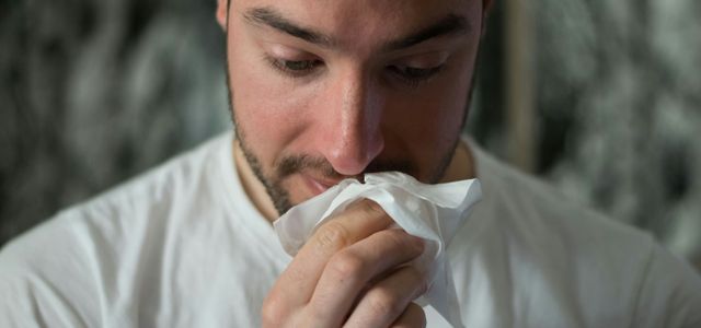 man wiping mouse with tissue paper
