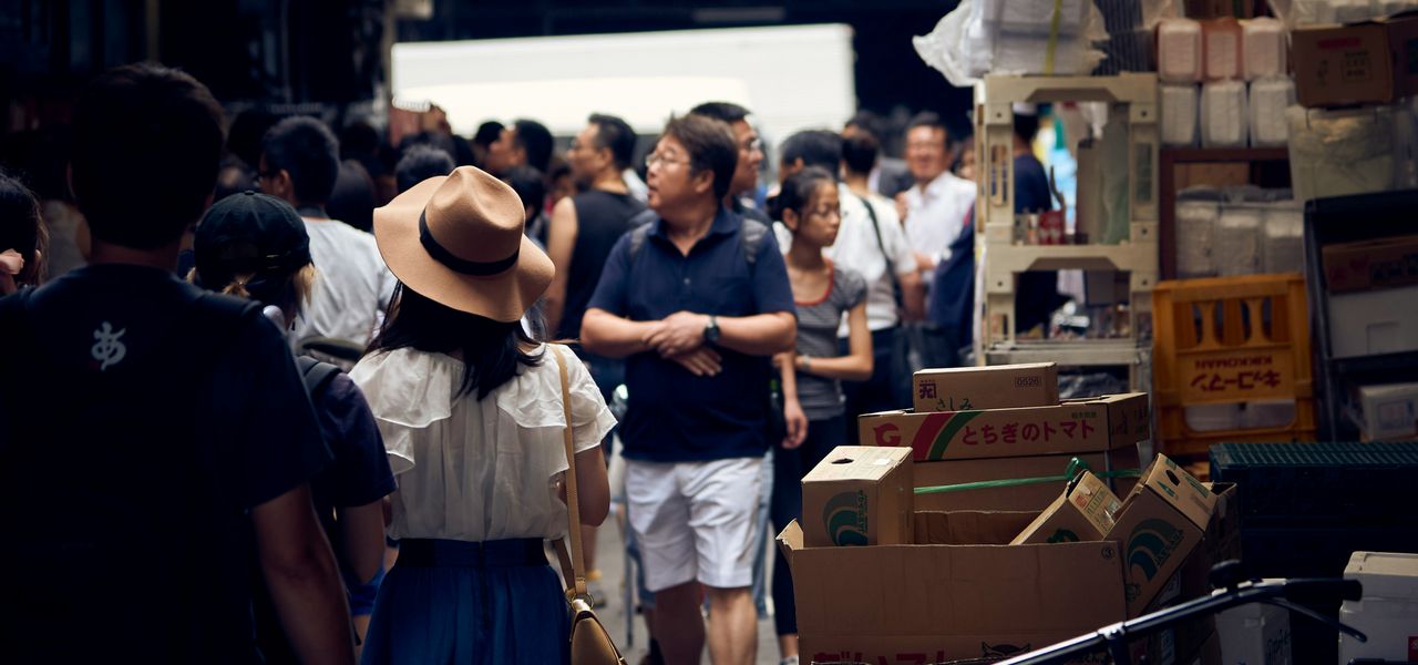people walking on street near cardboard boxes during daytime
