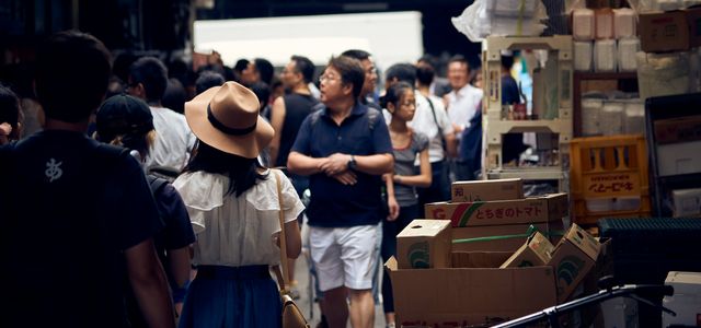 people walking on street near cardboard boxes during daytime