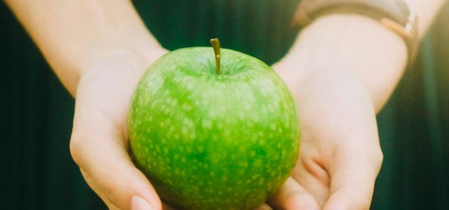 person holding green apple
