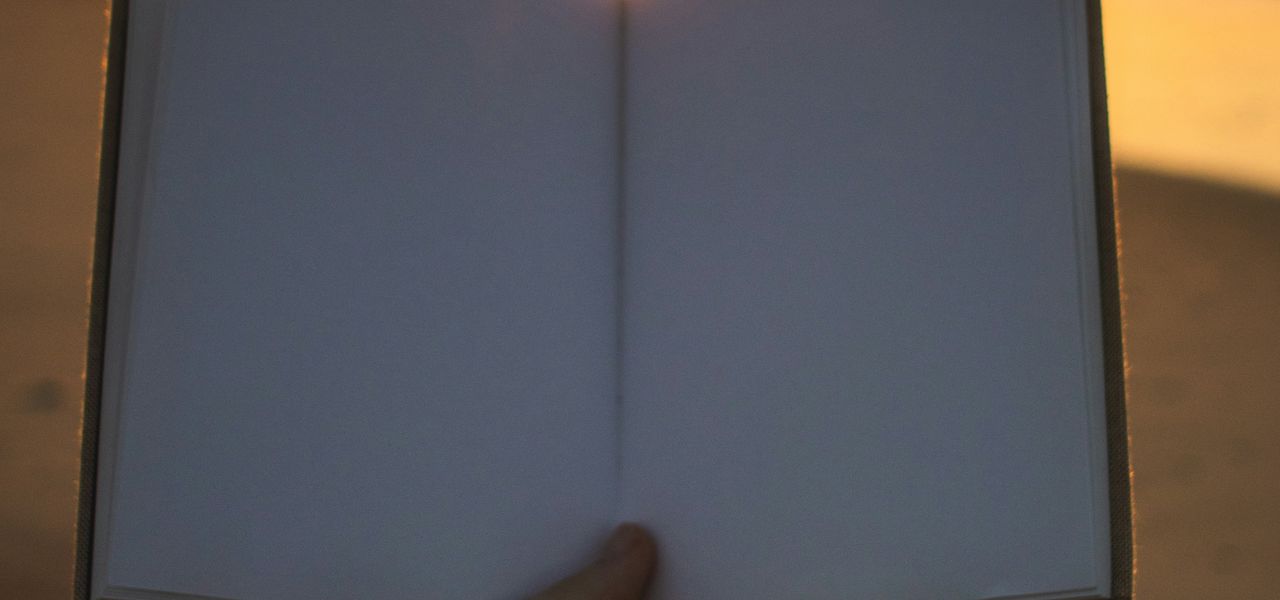 person holding open book with no print