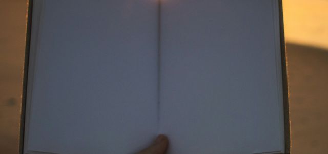 person holding open book with no print