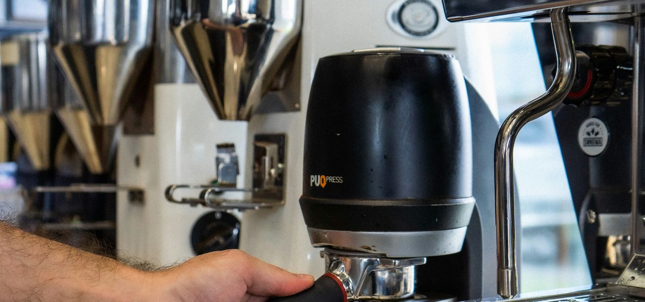 person holding silver and black coffee maker