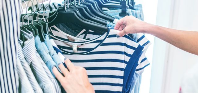 person holding white and black striped shirt