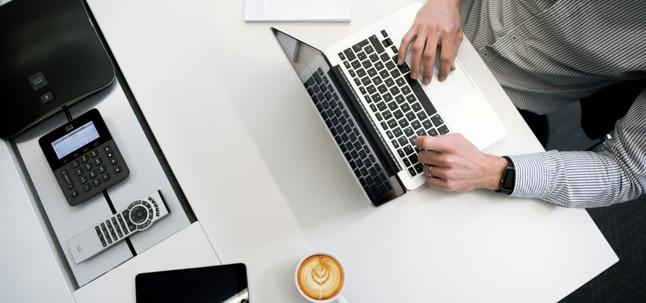 person using laptop on white wooden table