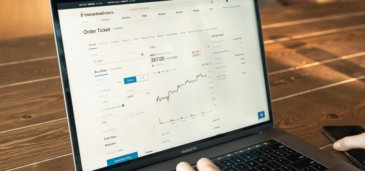 person using macbook pro on brown wooden table