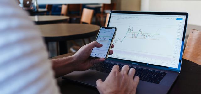 person using smartphone and MacBook Pro