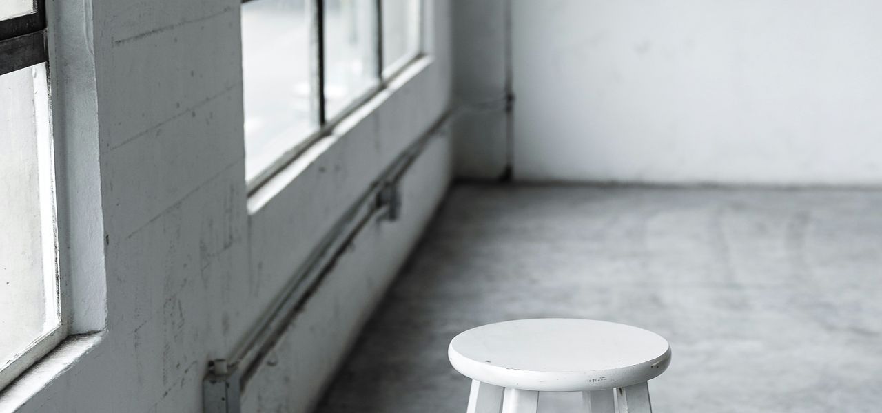 round white wooden stool near closed window