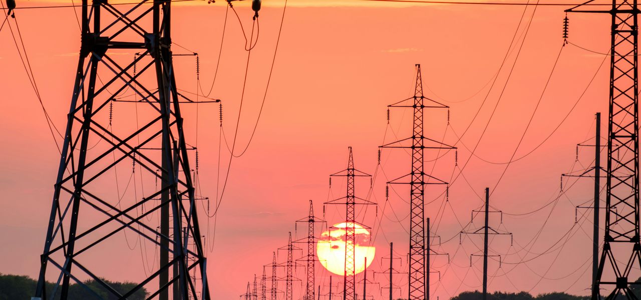 silhouette of electric post during sunset