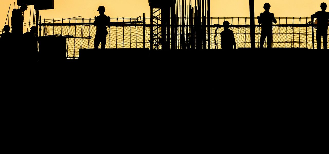 silhouette of people standing on tower crane during night time