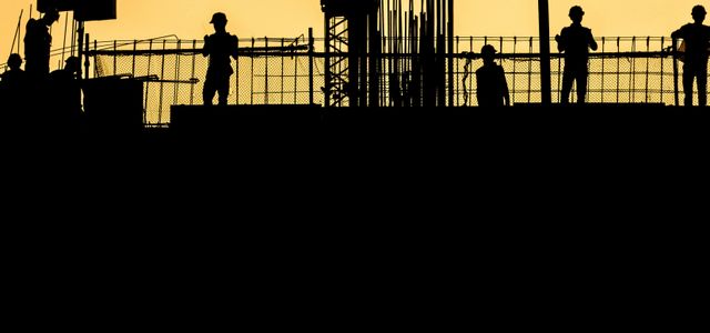 silhouette of people standing on tower crane during night time