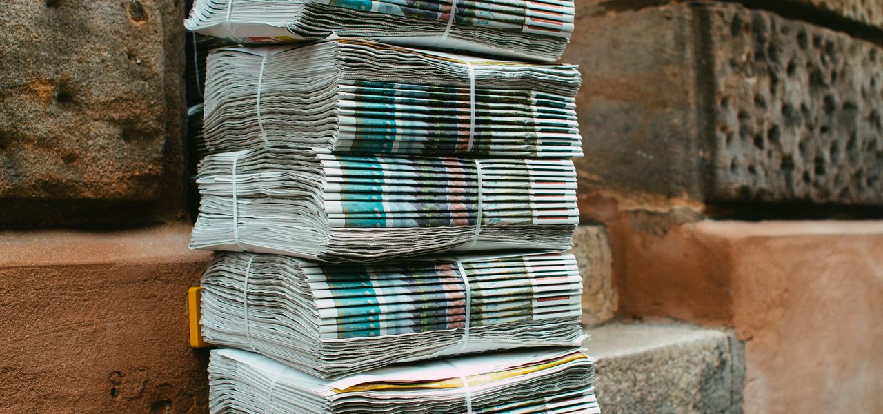 stack of white and blue books on brown concrete floor