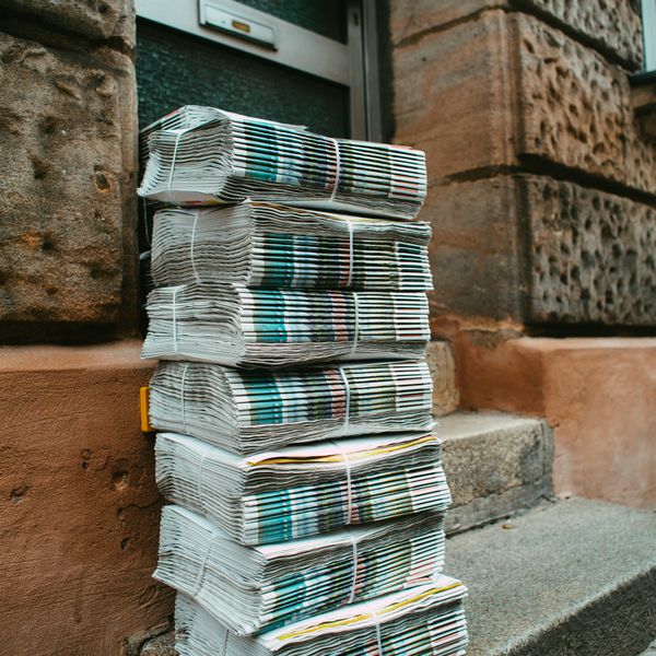stack of white and blue books on brown concrete floor