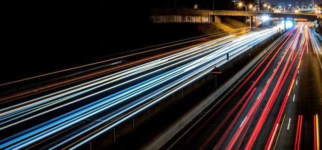 time-lapse photography of cars passing through the road during night time