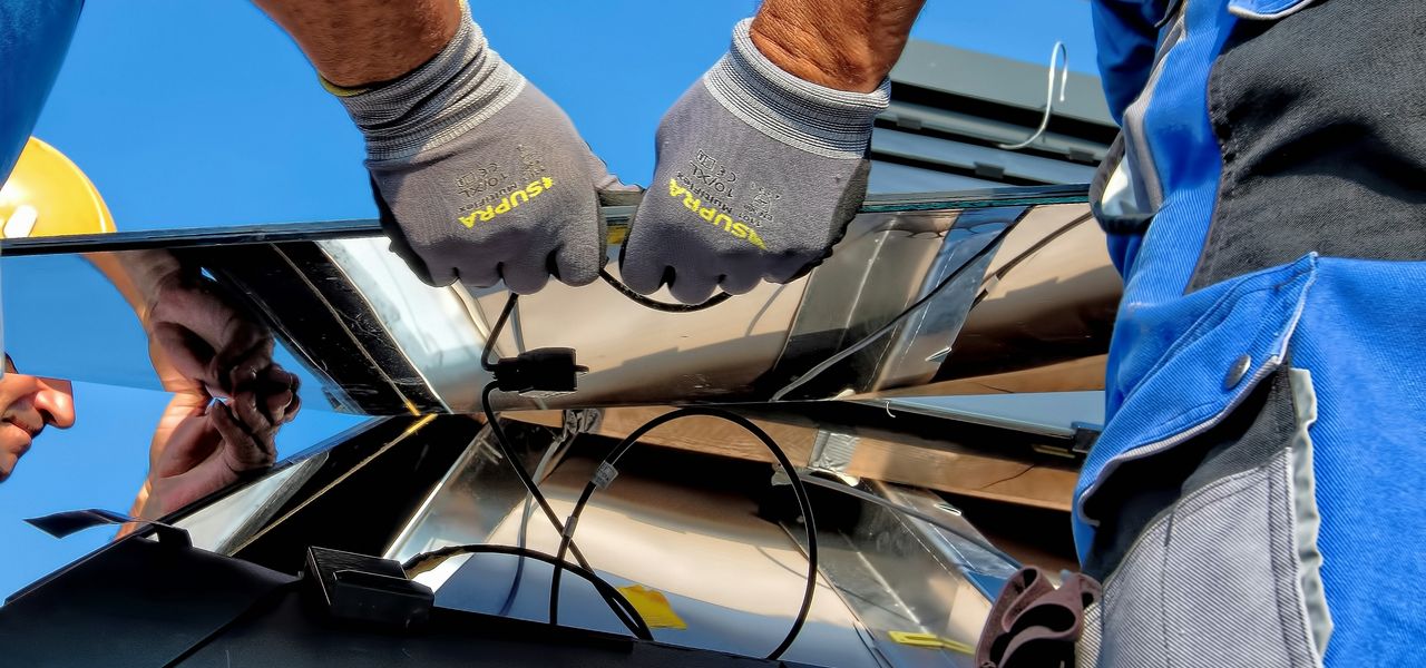 two men carrying a metal sheet