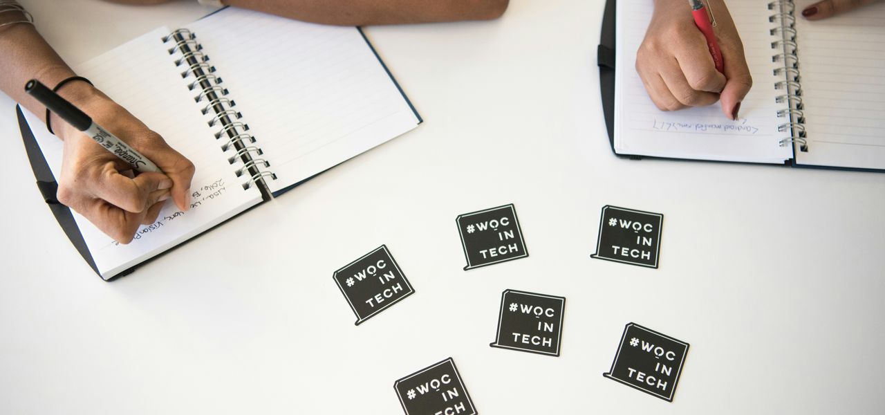 two people writing on notebooks