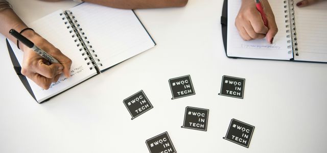 two people writing on notebooks