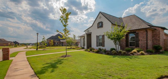 white and brown house near green grass field under white clouds and blue sky during daytime