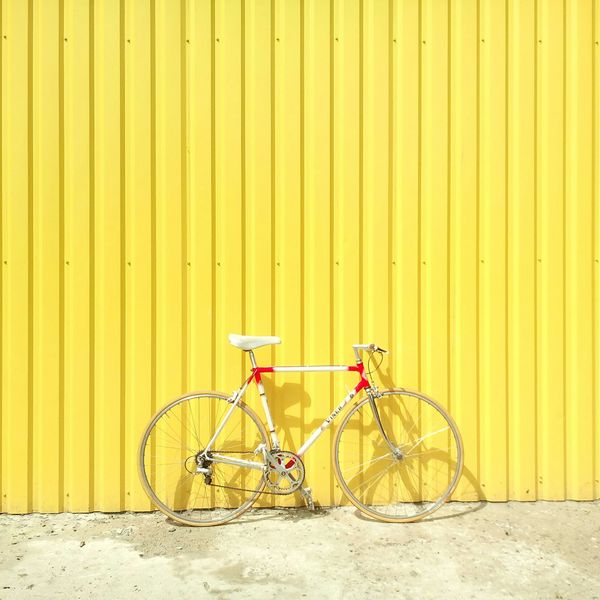 white and red hardtail bike on yellow wall