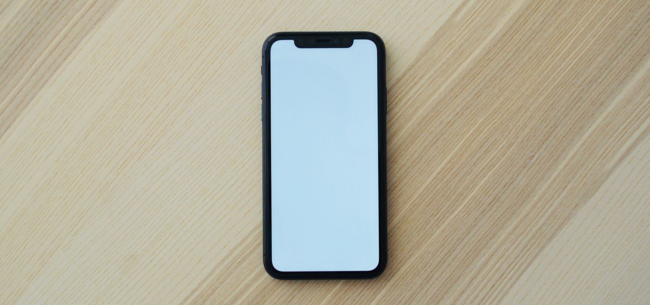 white smartphone on brown wooden table