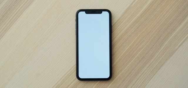 white smartphone on brown wooden table
