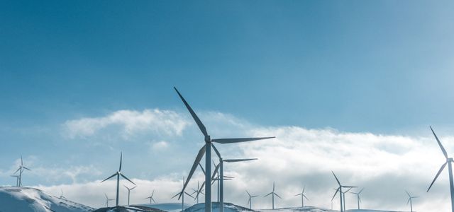 wind turbines on snowy mountain under clear blue sky during daytime