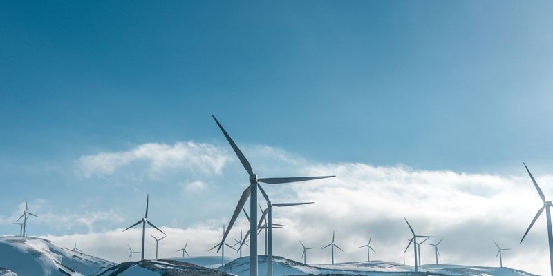 wind turbines on snowy mountain under clear blue sky during daytime