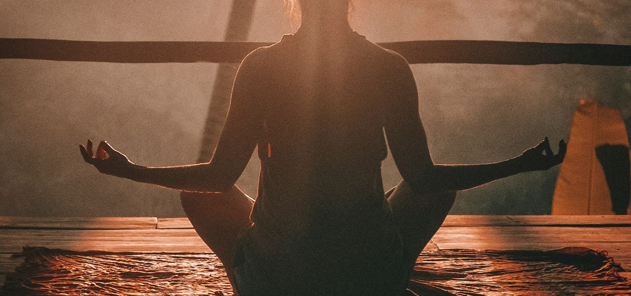 woman doing yoga meditation on brown parquet flooring
