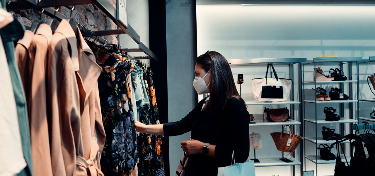 woman in black long sleeve shirt standing in front of clothes