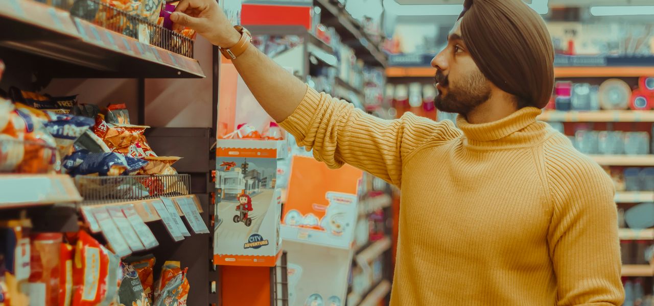 woman in yellow sweater holding red and white box
