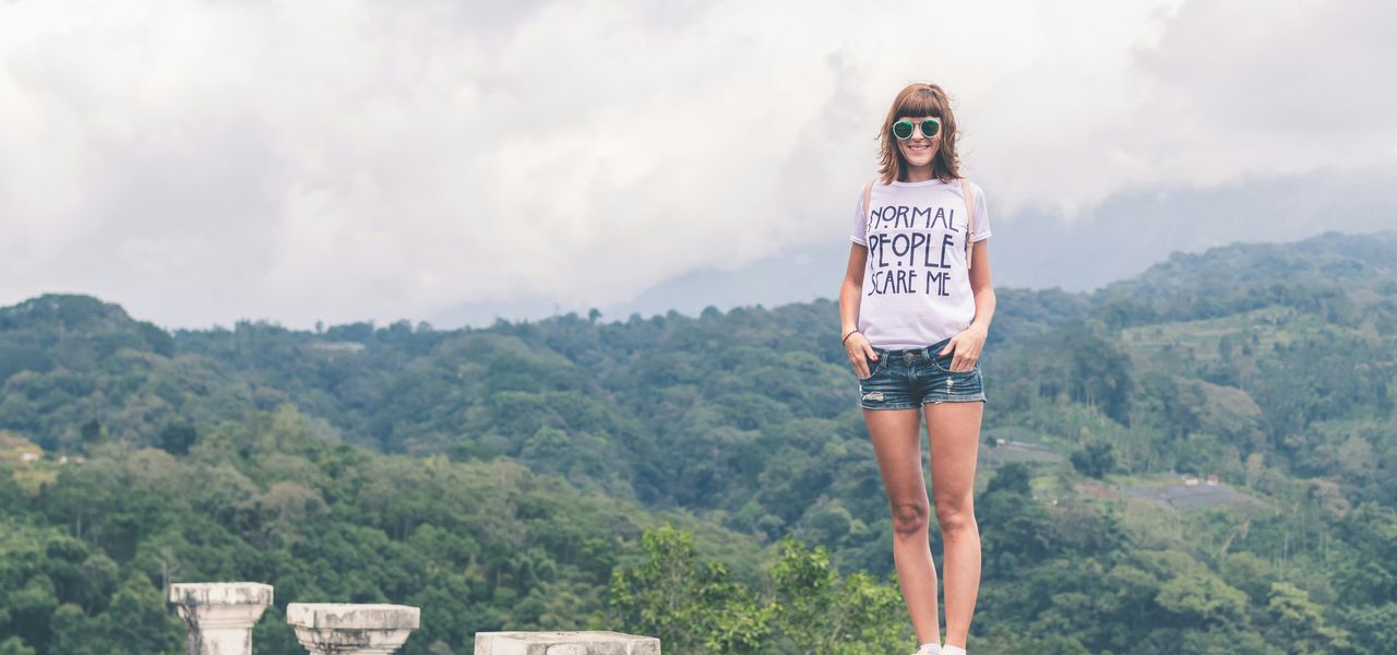 woman standing on concrete pillar