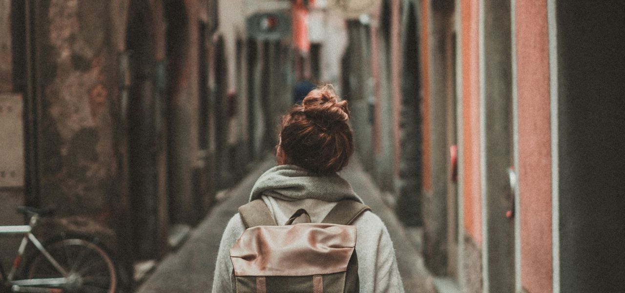 woman walking on street surrounded by buildings