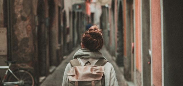 woman walking on street surrounded by buildings