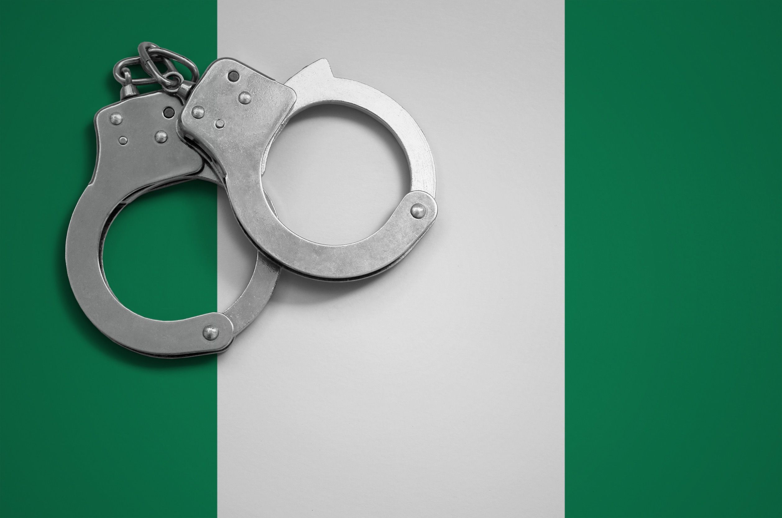 Handcuffs over Nigerian flag.