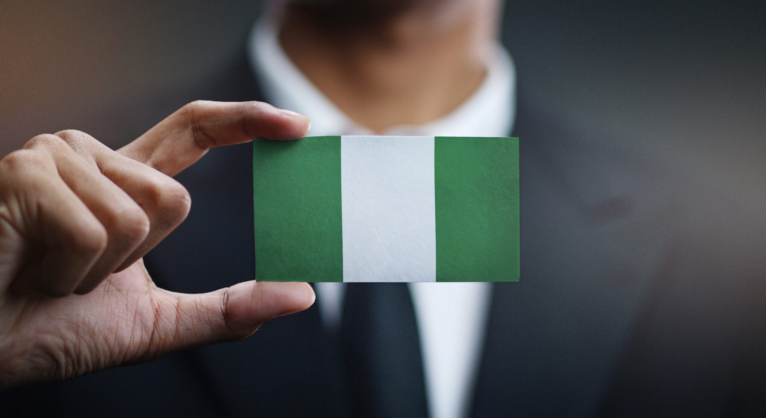 Man holding small Nigerian flag.