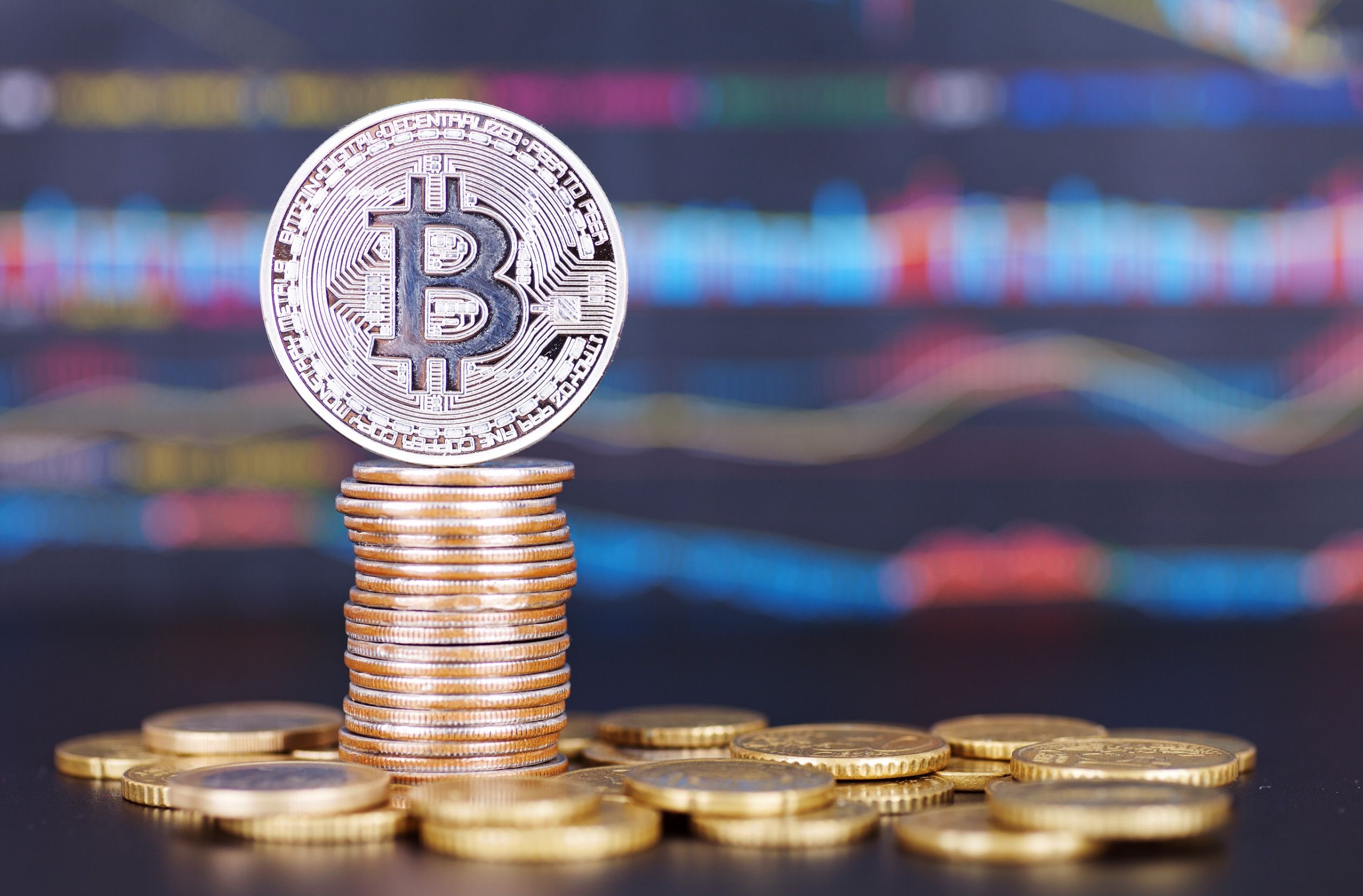 Bitcoin on top of a stack of coins.