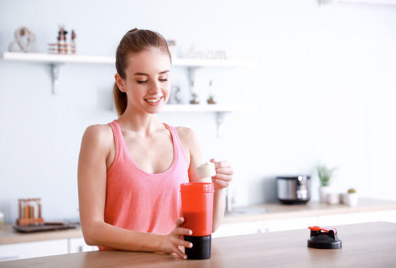Woman scooping Vitamin Sprinkles into a shaker in her kitchen