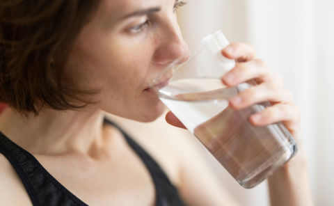 Woman drinking filtered water out of a glass