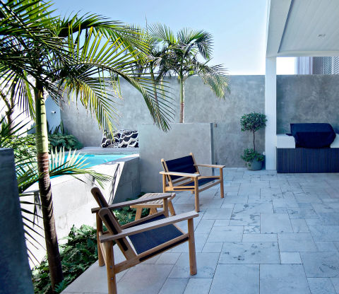 Outdoor seating area next to a raise pool, featuring stone tiling.