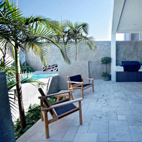 Outdoor seating area next to a raise pool, featuring stone tiling.