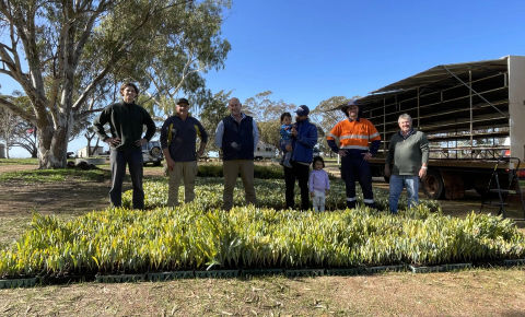 Group of people posing for photo in agricultural setting