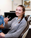 Teenage girl holding her retainer smiling at camera