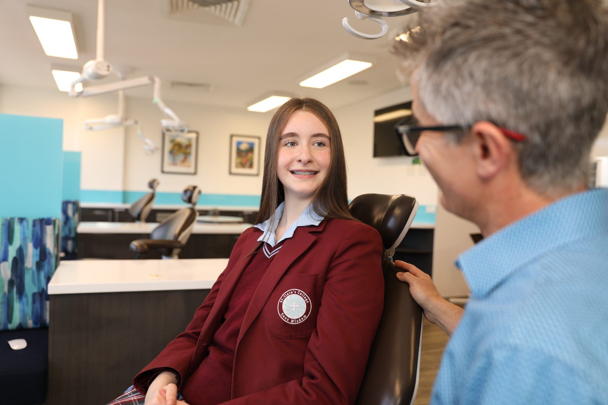 Orthodontist reassuring teenage girl