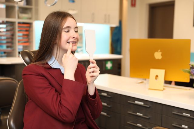 Teenage girl with braces looking into mirror
