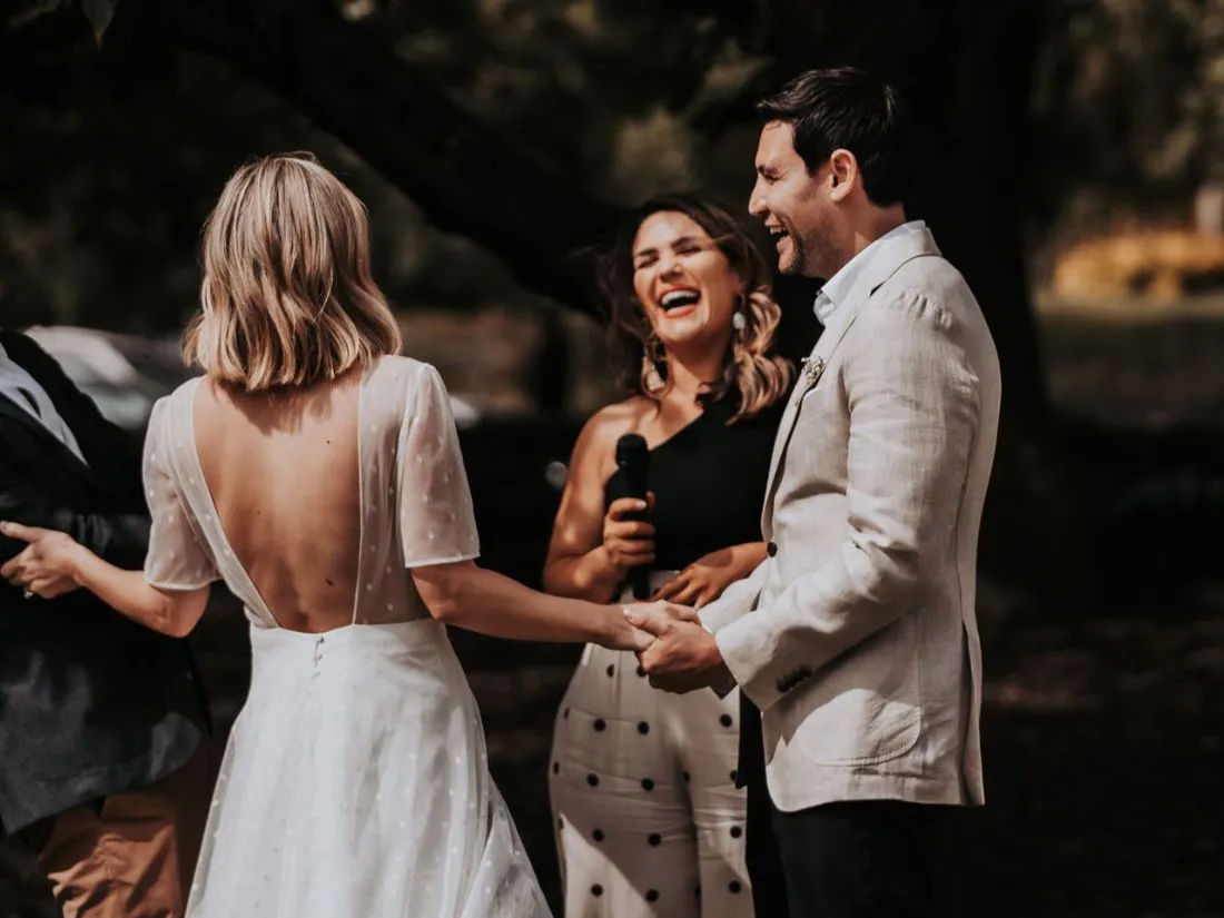 Celebrant Marry Me Tee laughs with her couples during a wedding ceremony