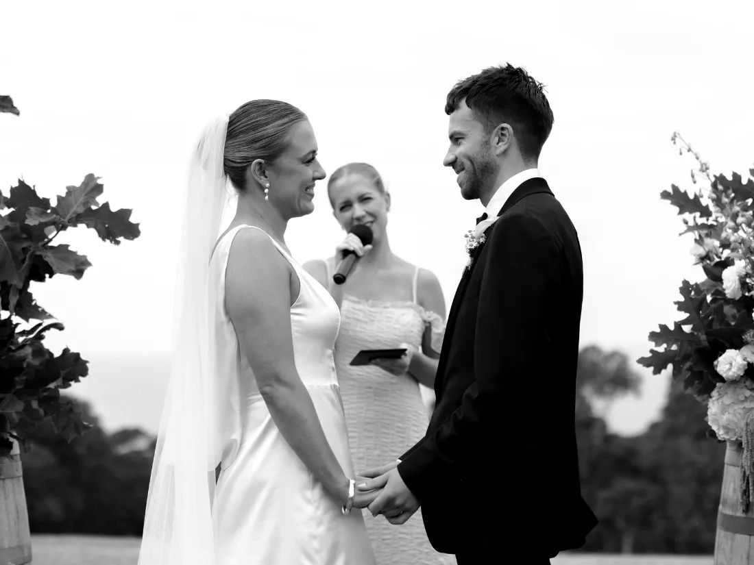 Brooke Brodie Celebrant standing between a couple in their wedding ceremony, in black and white.