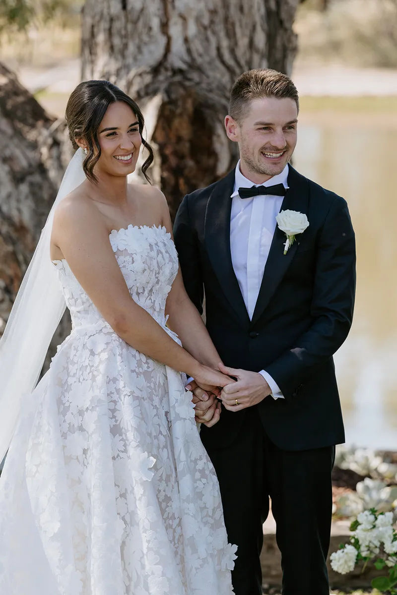 A close up of a couple holding hands during their wedding ceremony.