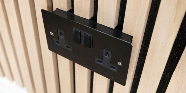 'Flat plate' screwless metal socket compared to a standard white one