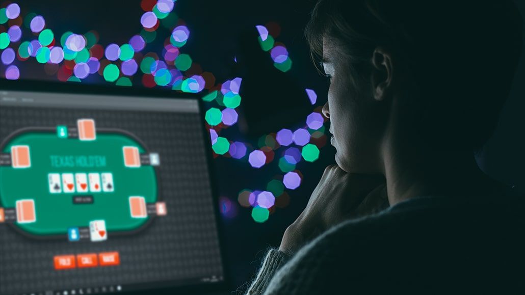 Close-up of a poker player's hands holding playing cards.