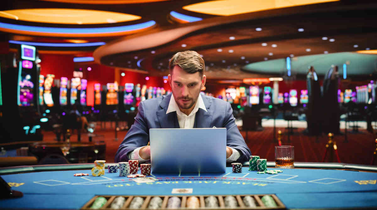 A person looking at a laptop screen showing a live casino game.